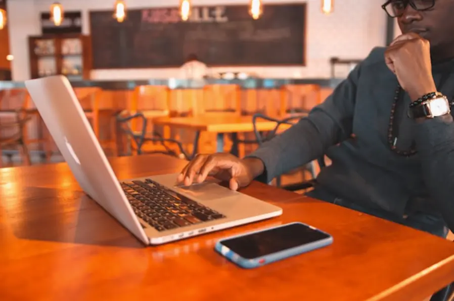a man sitting at a table using a laptop computer
