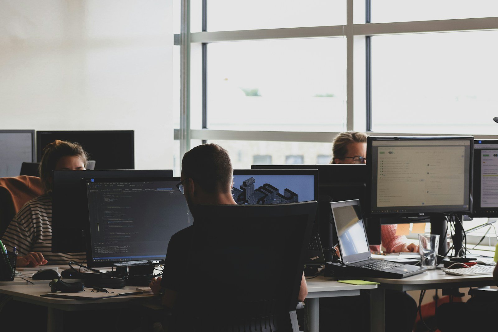 Analyste au travail devant plusieurs écrans