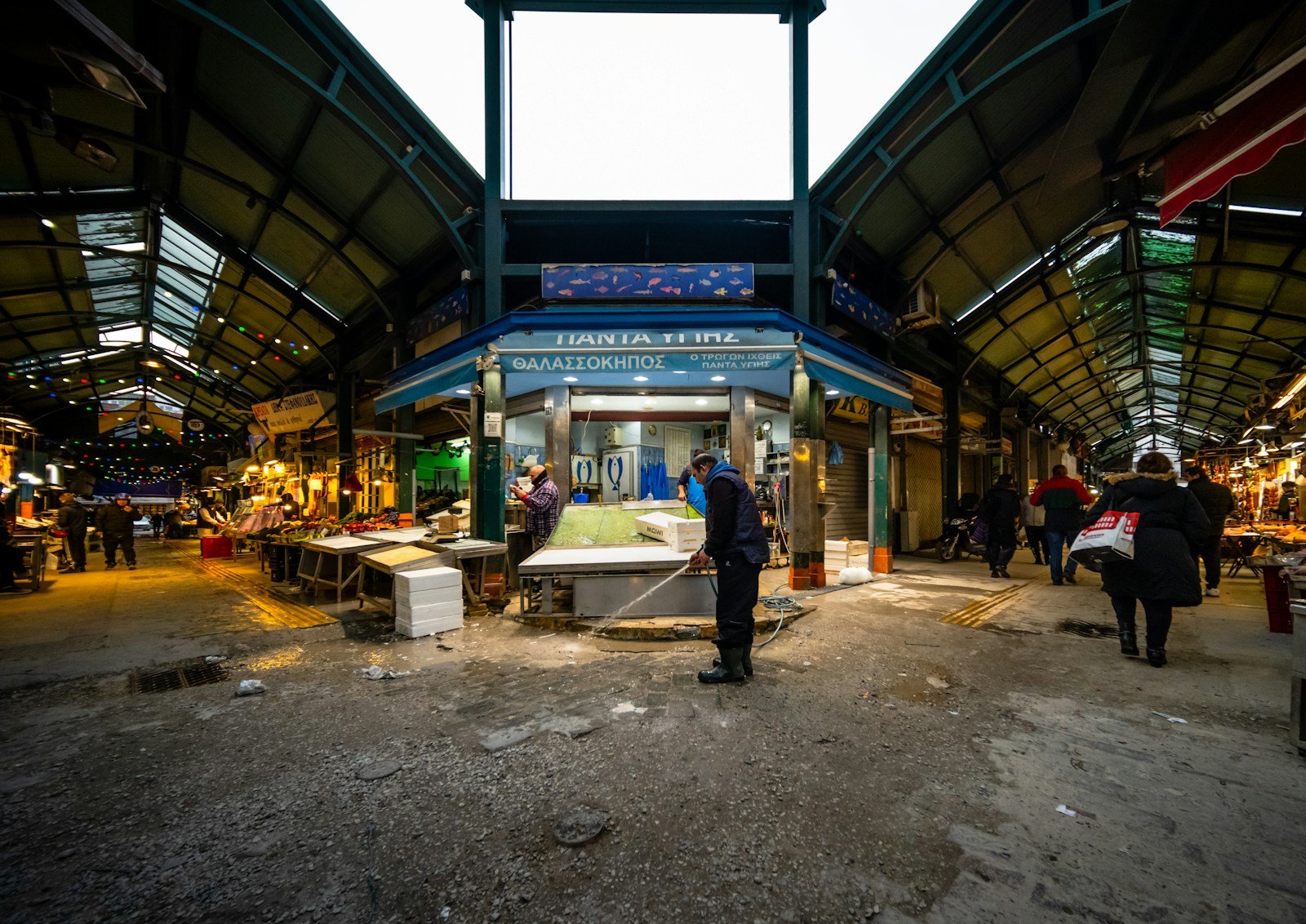 Cliente échangeant avec un commerçant en achetant ses légumes aux Halles d'Alès