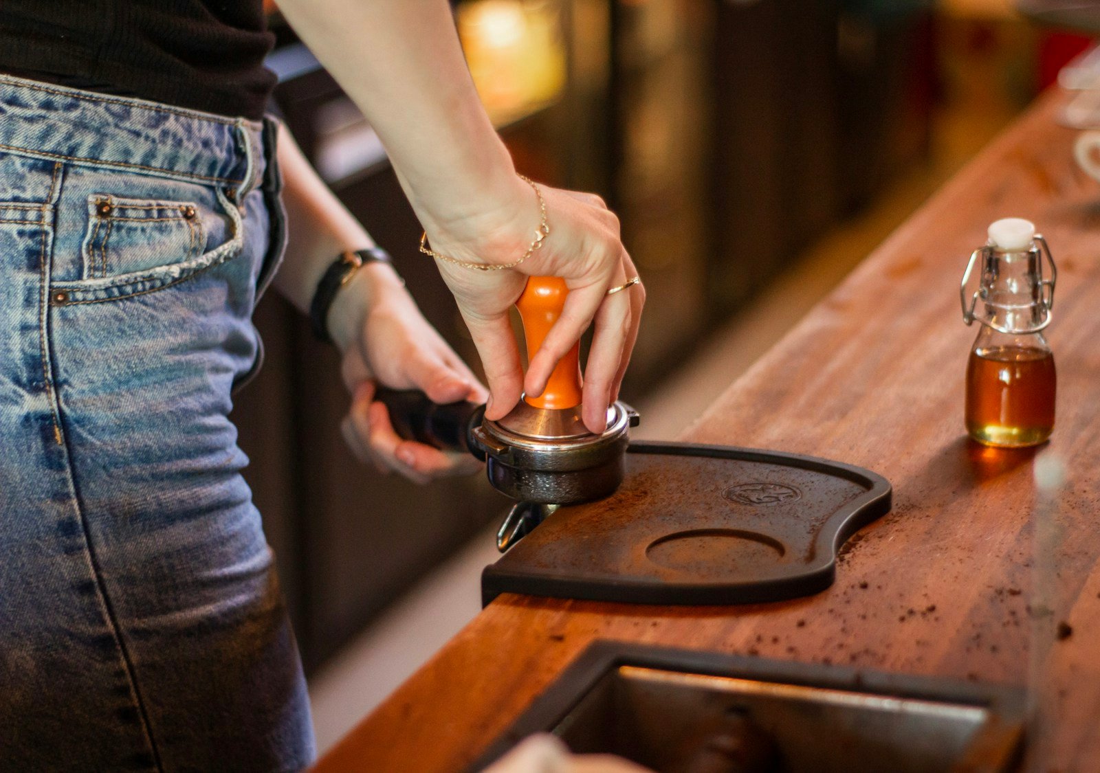 Deux mains pesant des pièces de monnaie sur une petite balance posée sur une table en bois