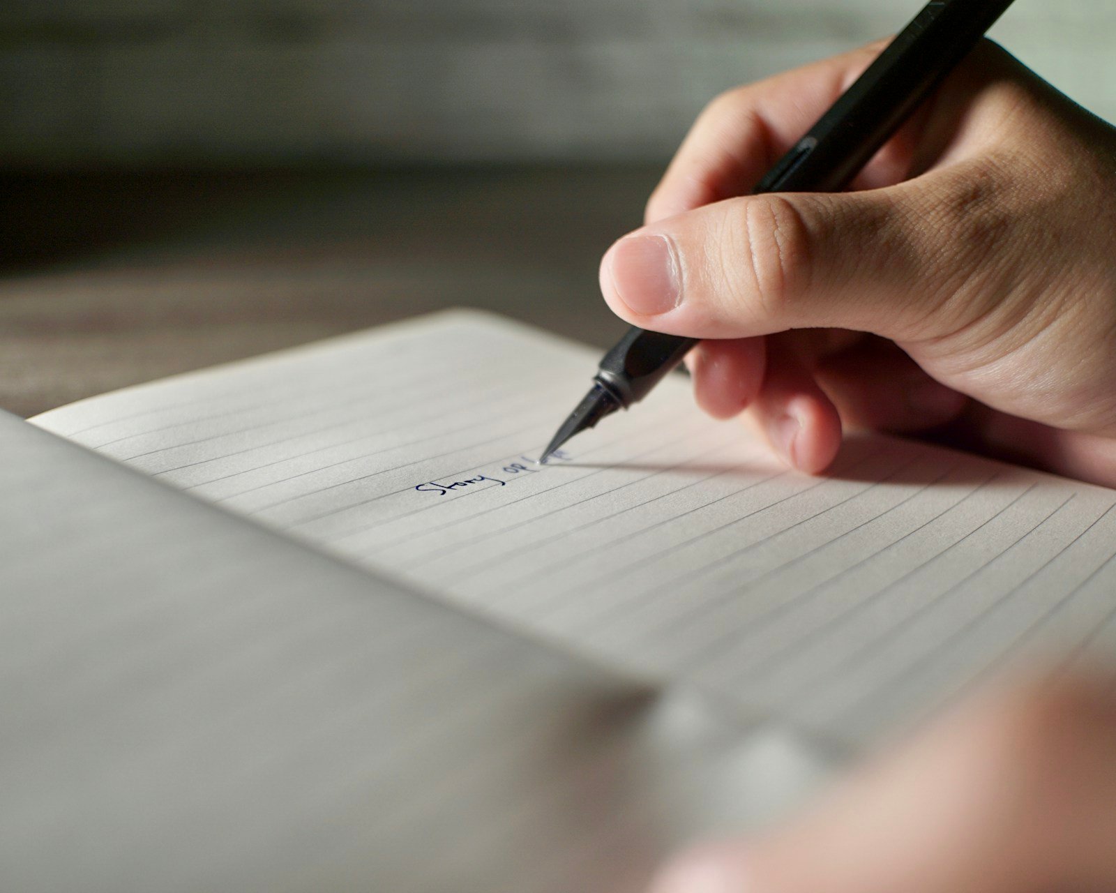 Main rédigeant un courrier formel au stylo