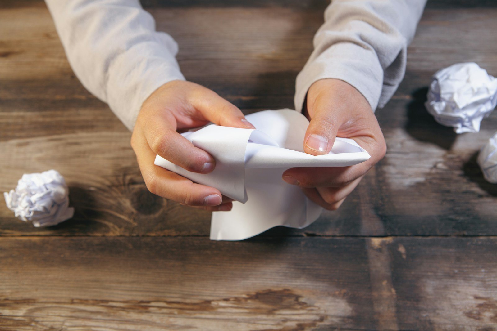 Mains triant de petites cartes en papier sur une table en bois