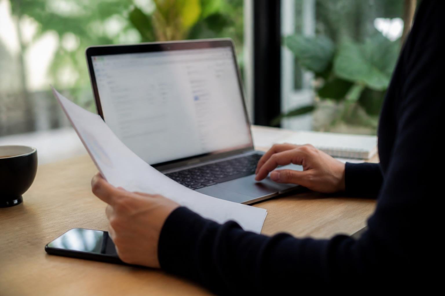 Personne joignant des documents à un email sur un ordinateur portable