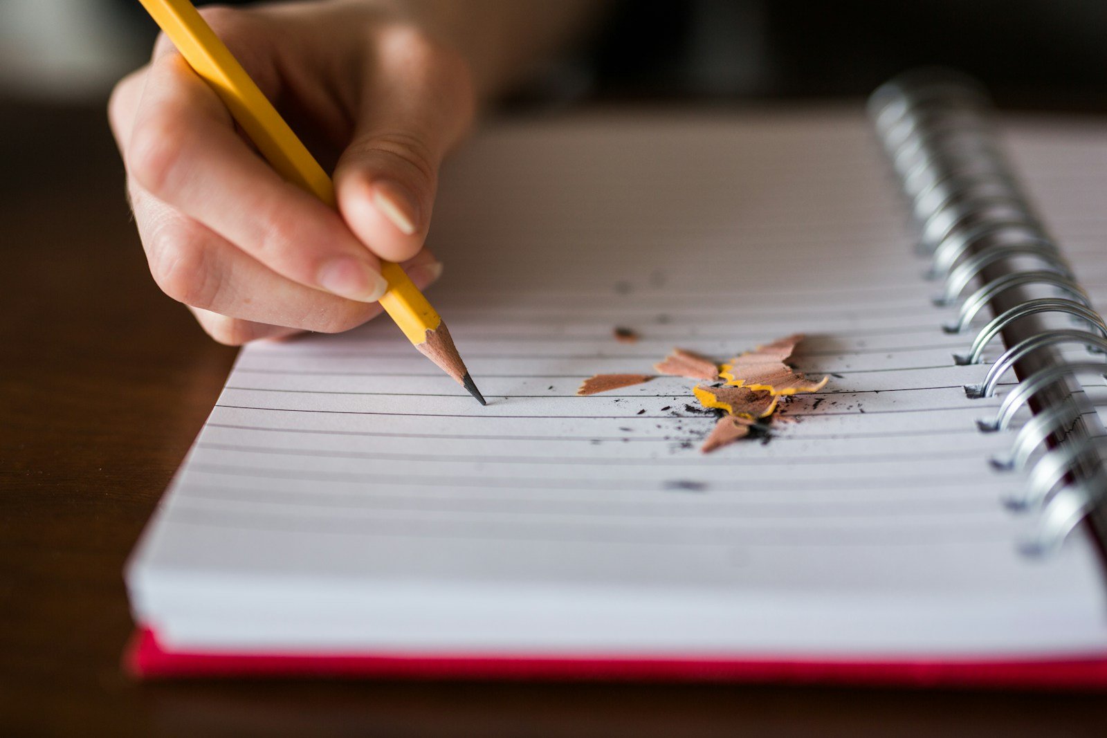 Personne réfléchissant à une règle de grammaire, carnet et crayon