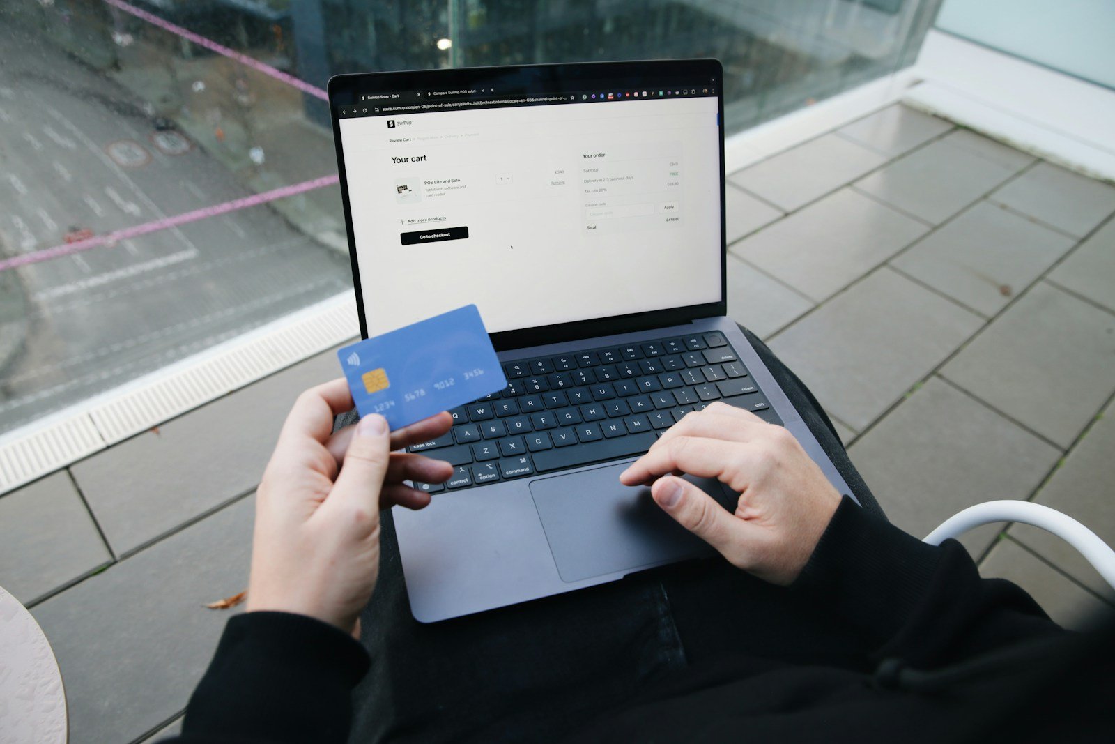 Personne remplissant un formulaire administratif en ligne avec une carte d'identité posée à côté