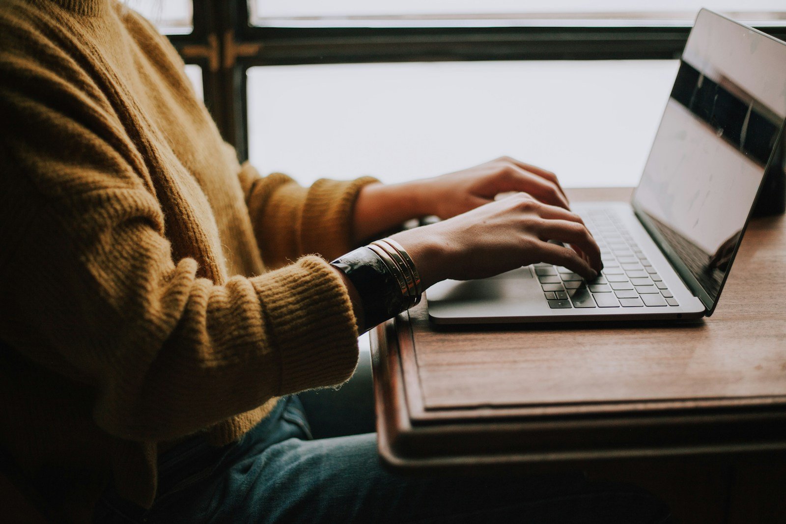 Personne remplissant une demande de financement en ligne sur un ordinateur portable