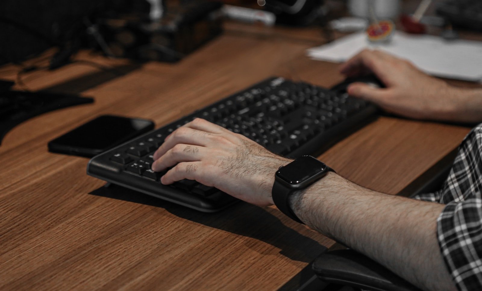 Personne souffrant d'une douleur à la main et au poignet devant son ordinateur de bureau