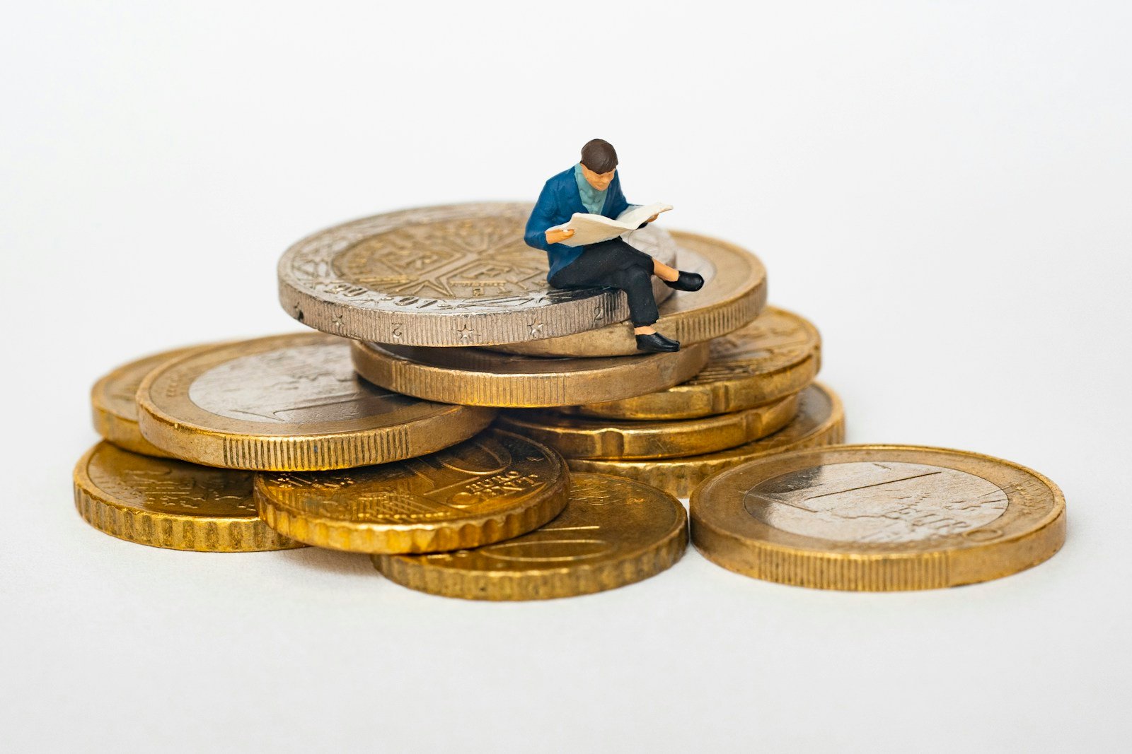Pièces d'euros empilées à côté d'un cahier d'école et d'une pomme rouge
