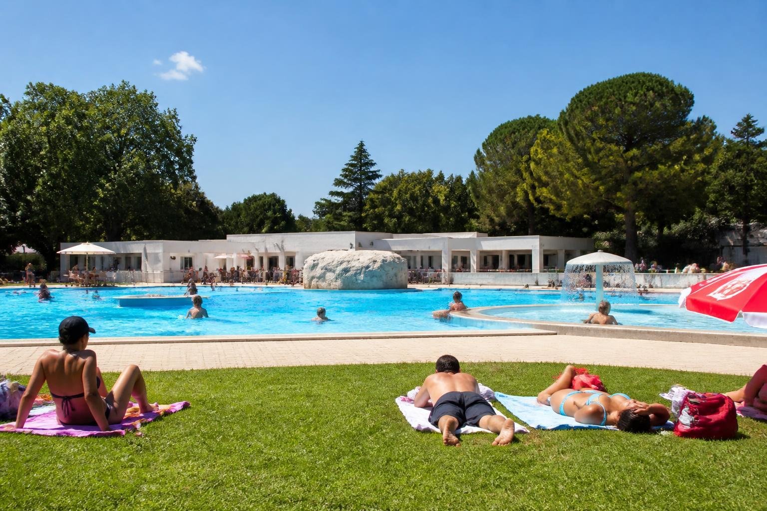 Piscine d'été en plein air de l'agglomération d'Alès sous le soleil, avec baigneurs et pelouse