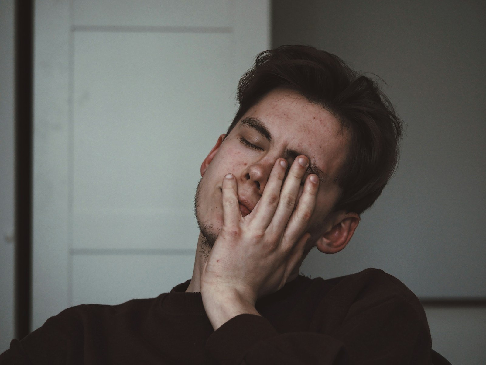 Salarié fatigué se frottant les yeux dans une salle de pause la nuit