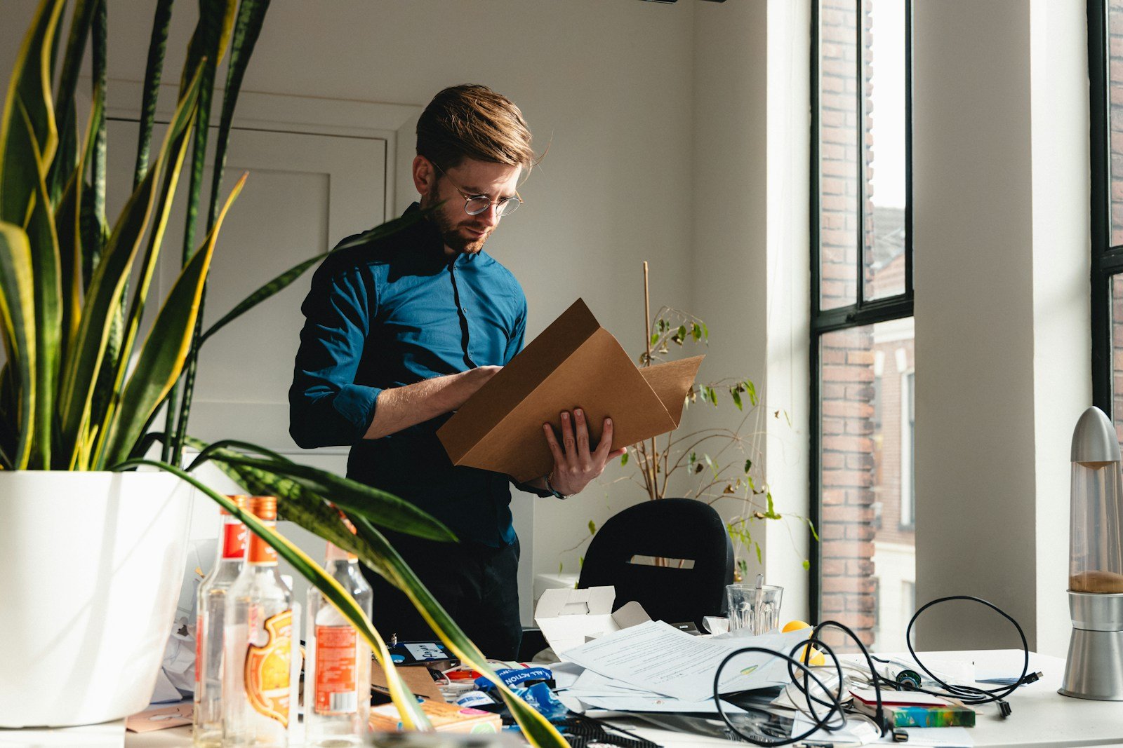 Travailleur classant des documents papier et bulletins de paie dans une pochette